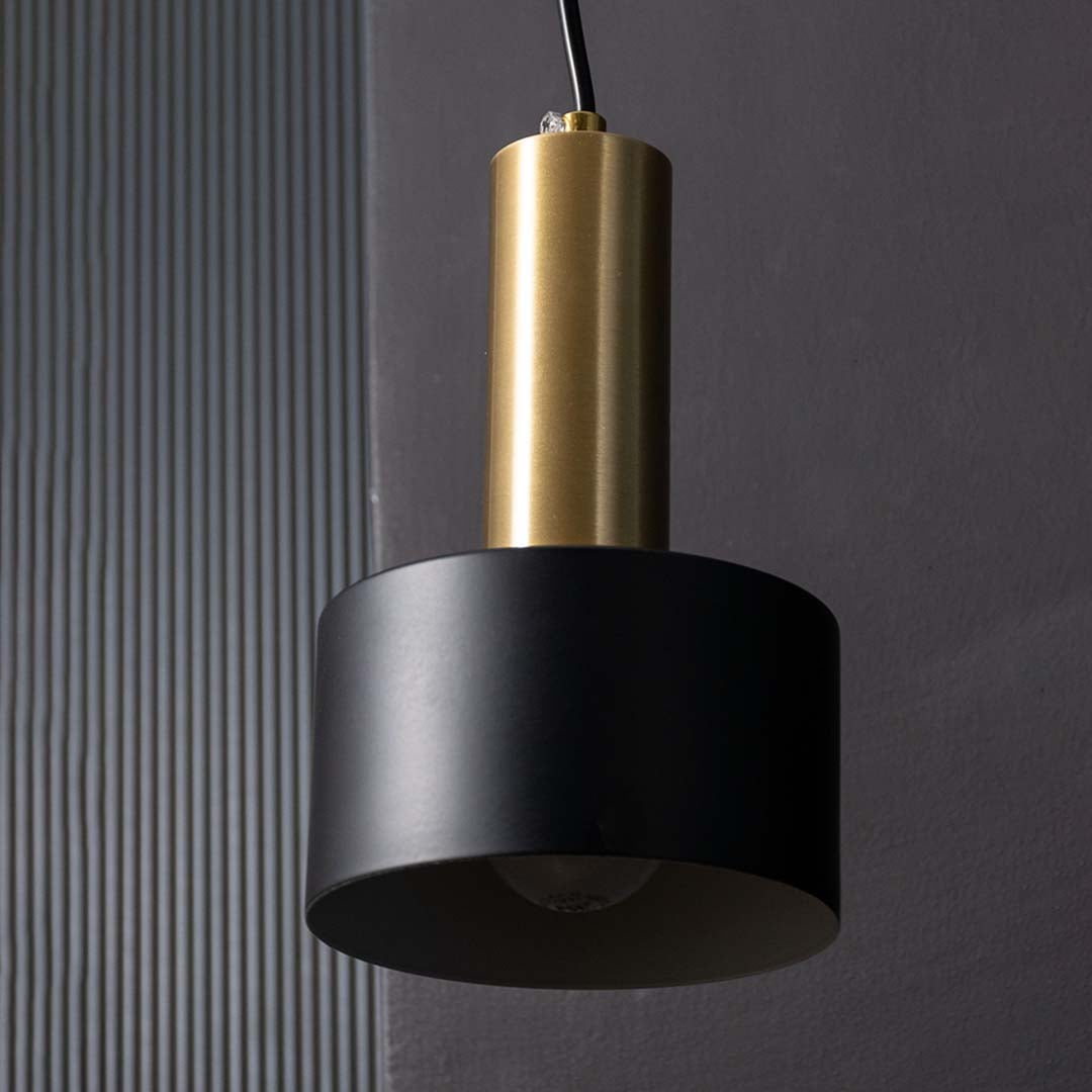 Detailed view of black and gold cylinder shade of modern hanging wall lamp showing focused lighting effect and smooth matte finish.