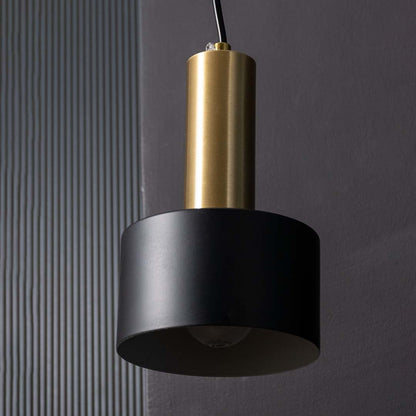 Detailed view of black and gold cylinder shade of modern hanging wall lamp showing focused lighting effect and smooth matte finish.