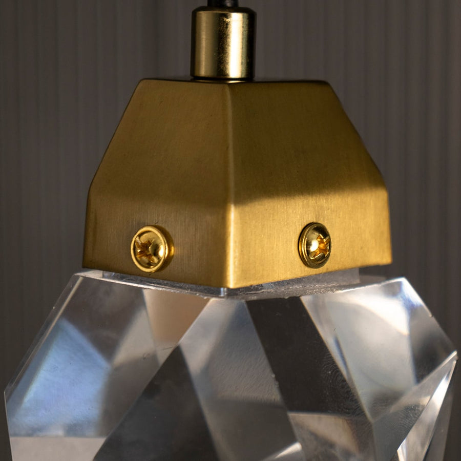 Detailed view of crystal pendant lamp highlighting geometric glass design and gold metal finish for luxury lighting.