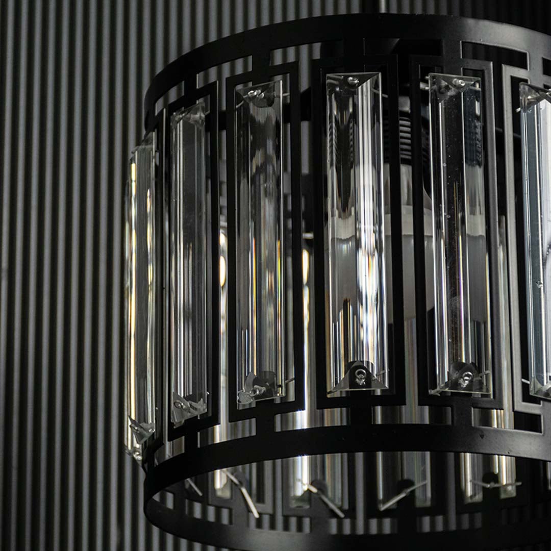 Detailed view of black metal and smoked glass chandelier showcasing refined texture and finish.