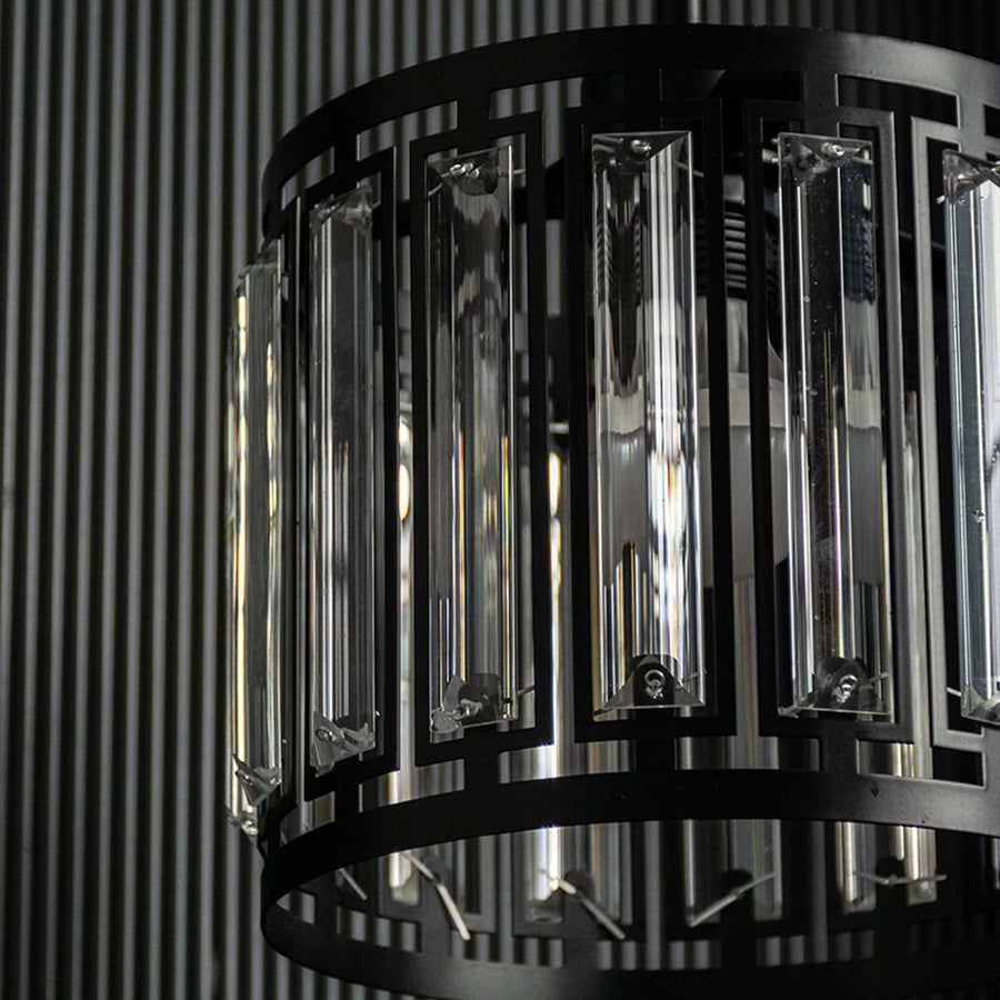 Detailed view of black metal and smoked glass chandelier showcasing refined texture and finish.