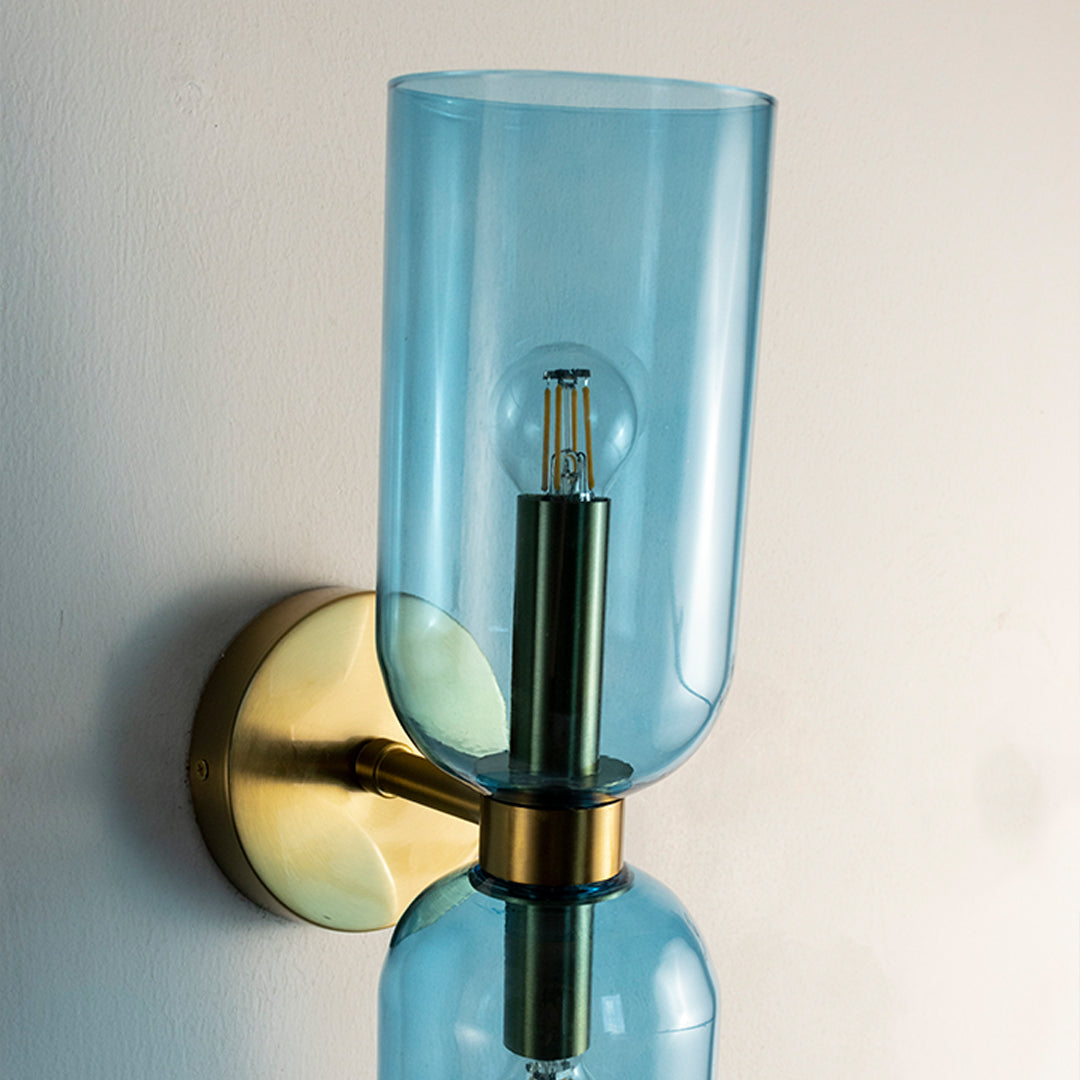Closeup of blue glass and gold metal wall light for modern bedroom hallway and luxury decor styling spaces.

