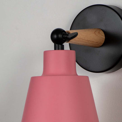 Closeup view of wooden wall sconce with pink lampshade elegant modern indoor wall light for bedroom kids room and hallway lighting decoration.