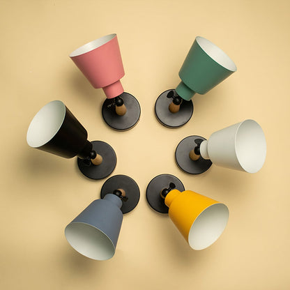 Grouped colorful wall lights with cone shades arranged creatively on wall creating playful modern lighting decor for interiors.