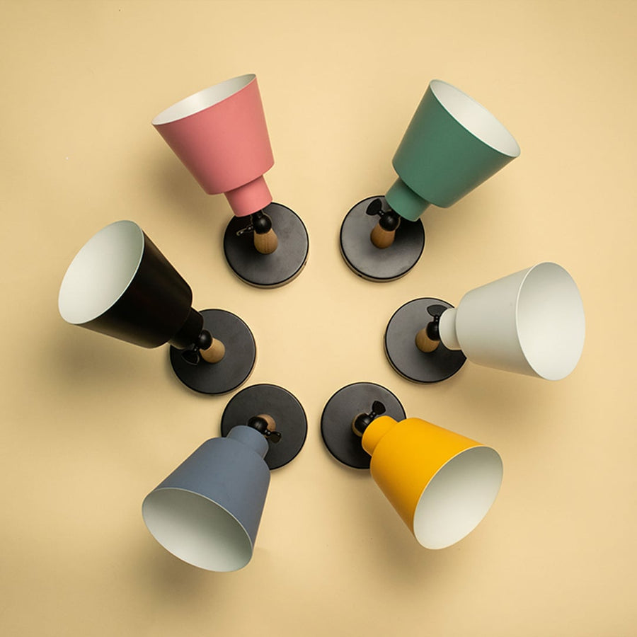 Grouped colorful wall lights with cone shades arranged creatively on wall creating playful modern lighting decor for interiors.