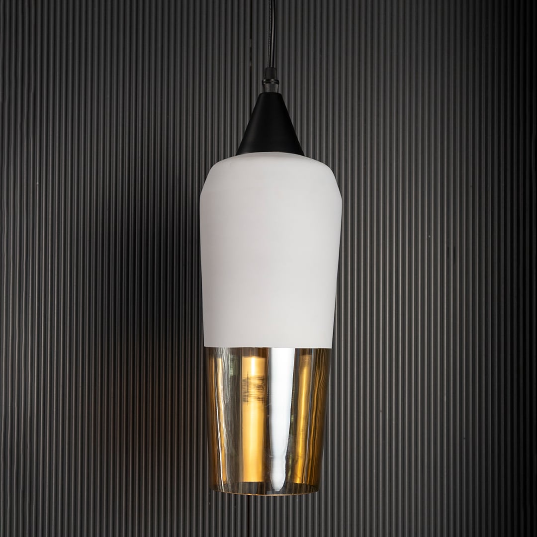 Sleek cylindrical hanging light fixture with white top and amber bottom turned off isolated on a pitch black background for high contrast.