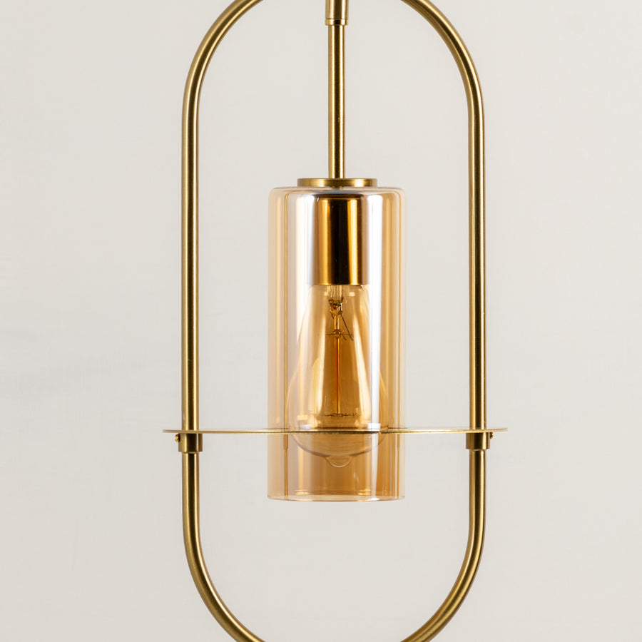 Closeup of gold metal pendant light with exposed bulb for elegant kitchen and dining room decor styling.