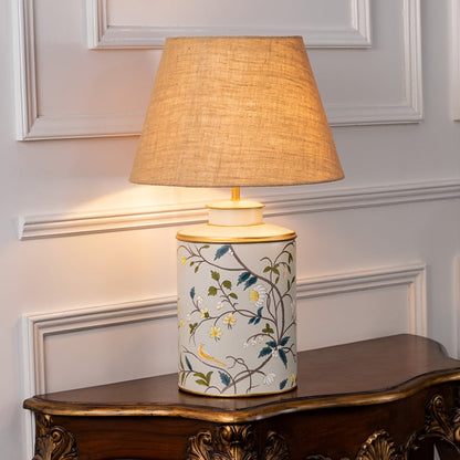 Moghul Bagh table lamp switched on displayed on white background casting warm glow with ornate pattern ideal for elegant interior decor.