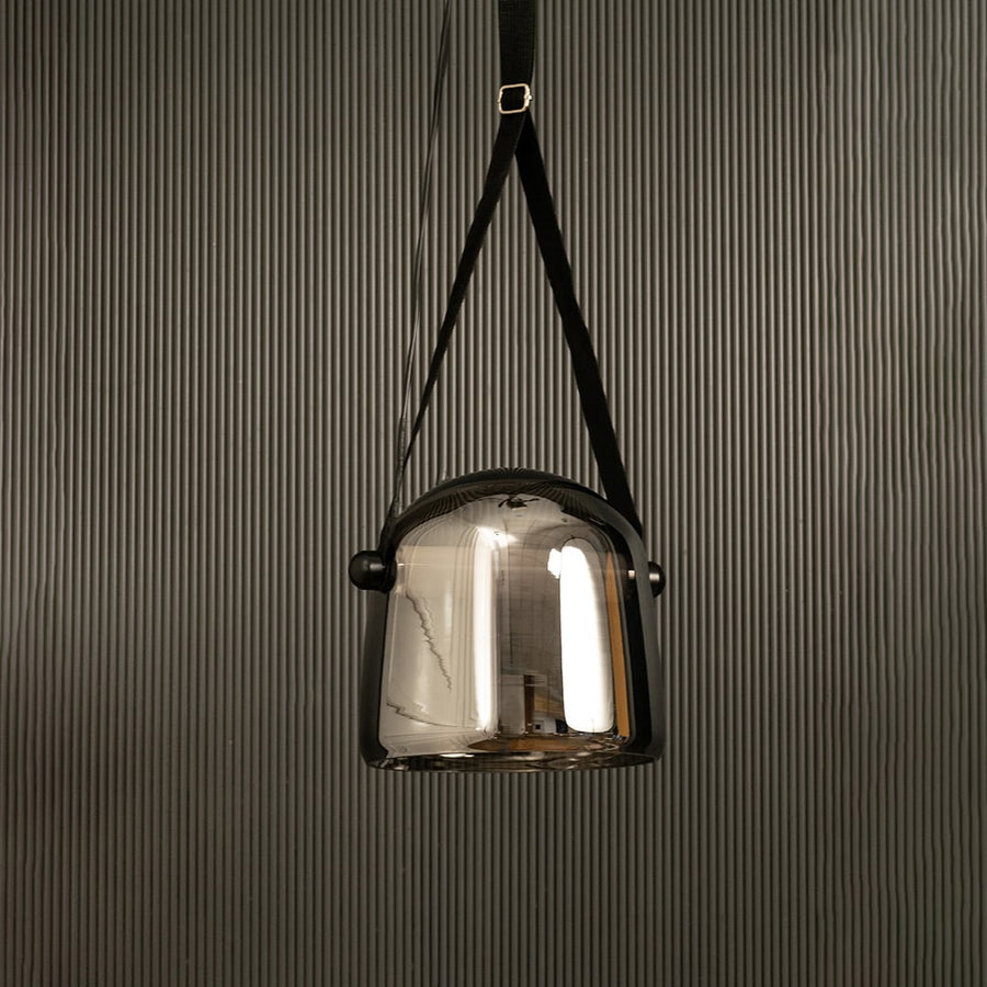 Modern chrome glass pendant lamp with black strap displayed on black background adding style to interior design.