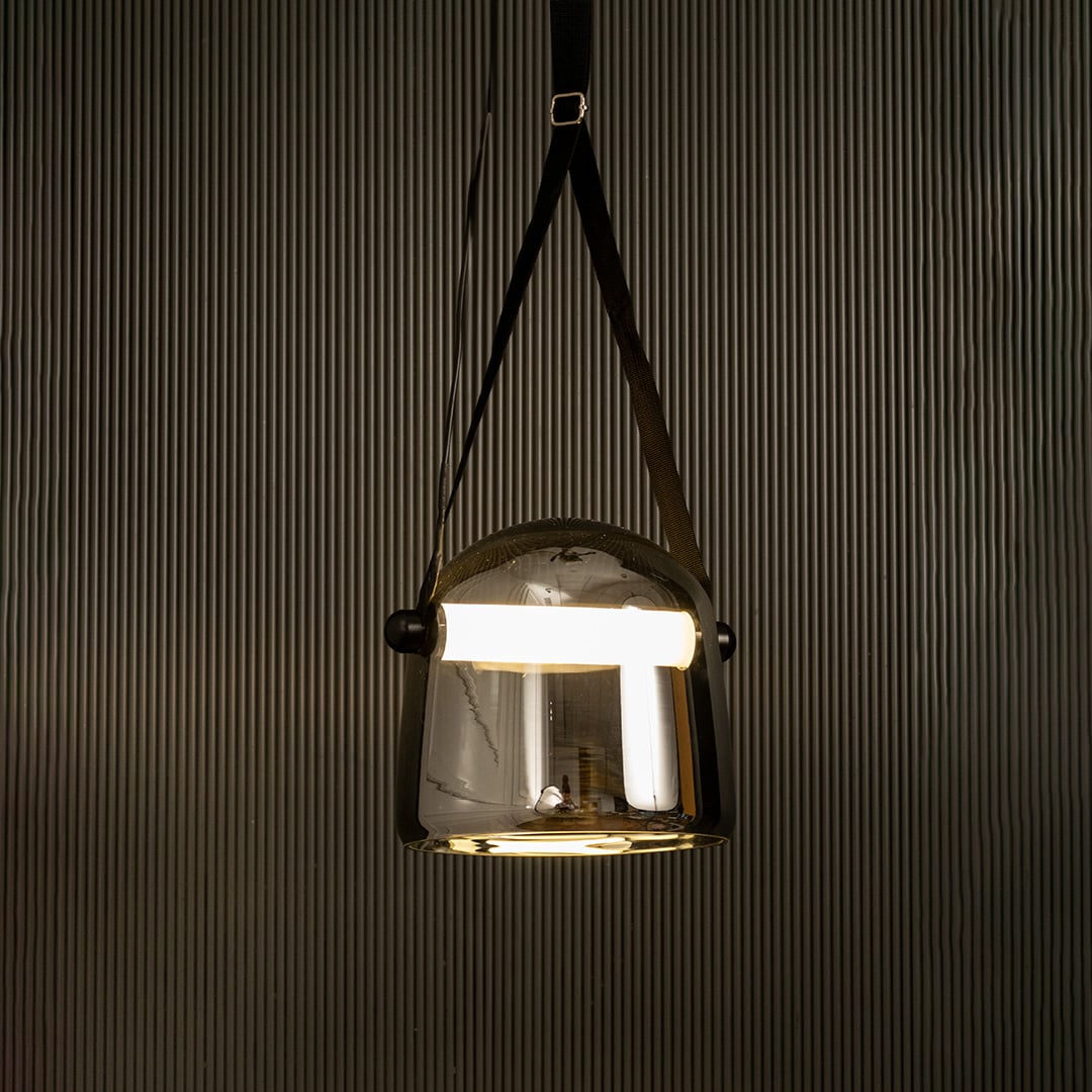 Chrome glass pendant light glowing beautifully on black background ideal for living room or dining space lighting.