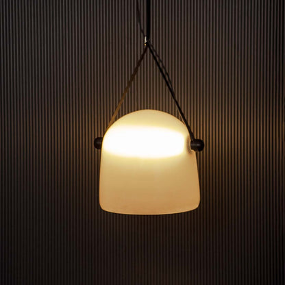 Frosted white glass pendant light glowing on black background perfect for stylish dining or living room lighting.