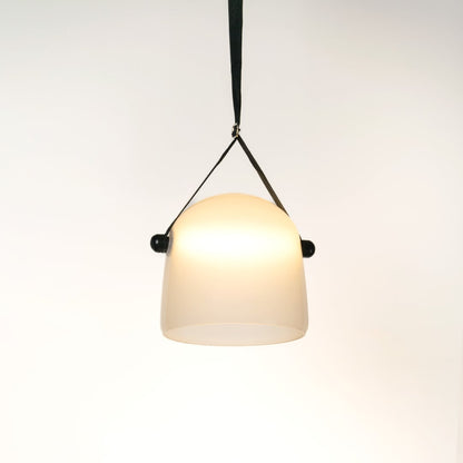Frosted white glass pendant light illuminated on white background adding soft modern glow to home interiors.