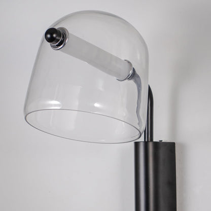Closeup of clear glass wall lamp with black metal fixture showing minimalist design perfect for modern home wall lighting.