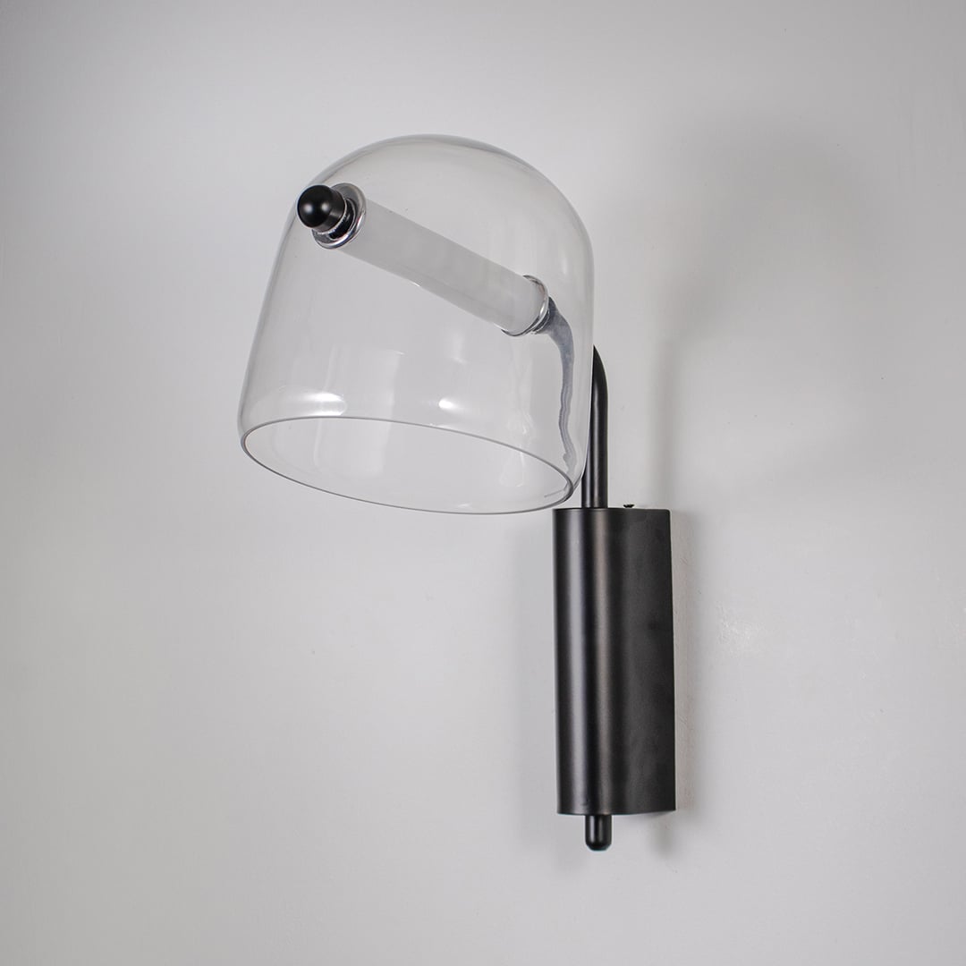Clear glass wall light with black metal base light off on white background modern wall lighting for bedroom and hallway.
