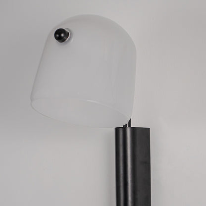Modern white wall light with cylindrical black metal elements mounted on soft neutral wall background perfect for contemporary decorative lighting.

