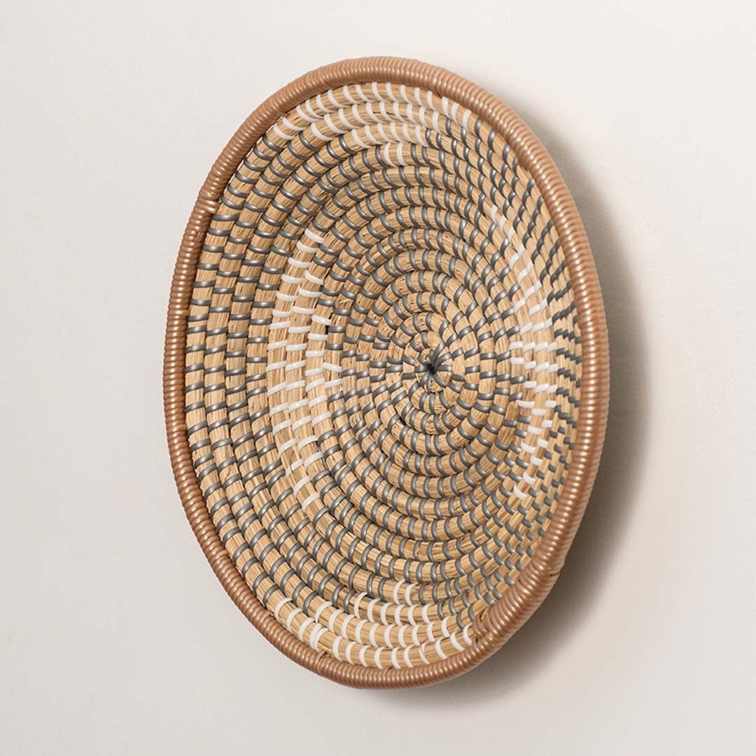 Side view of woven wall plate showing depth and curved rim made from durable handwoven natural fibers.