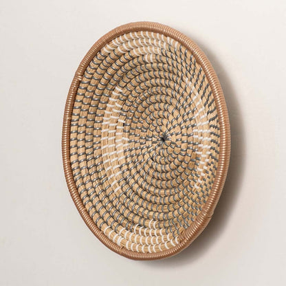 Side view of woven wall plate showing depth and curved rim made from durable handwoven natural fibers.