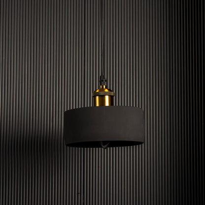 Black concrete pendant light turned off showcasing matte texture and brass accent for contemporary lighting design.