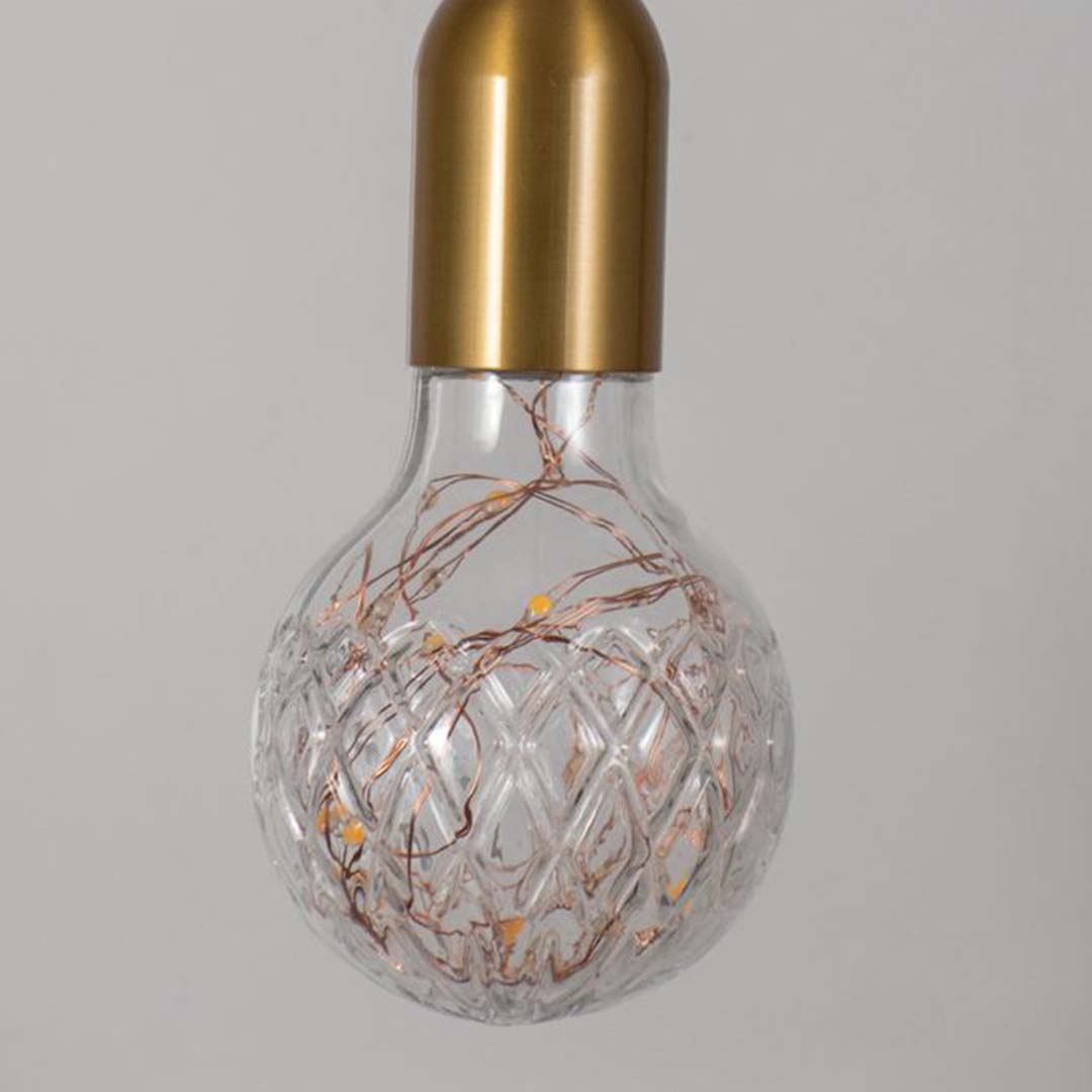 Closeup of pendant light with golden holder and crystal cut glass bulb stylish modern ceiling lamp for luxury home interior lighting.