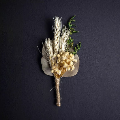 Elegant dried flower bouquet with wheat stalks preserved greenery and rustic jute wrap displayed on black background.