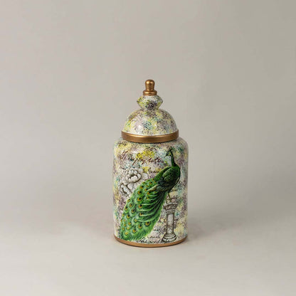 Ceramic jar with green parrot and botanical artwork and gold lid placed on white surface against neutral background enhancing elegant artistic home decor styling.