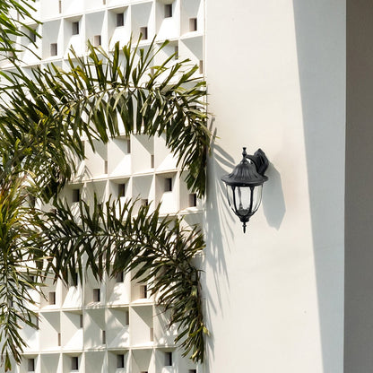 Black metal outdoor wall light lifestyle image on modern exterior wall for elegant patio lighting decor.