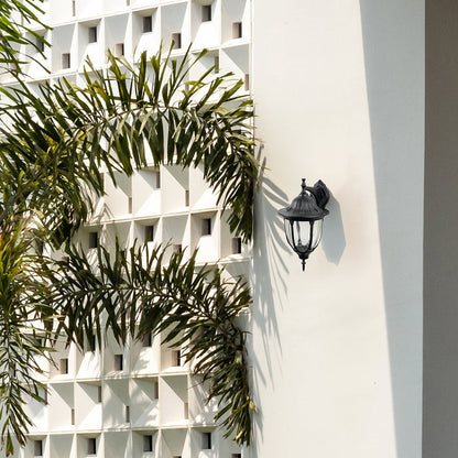 Black metal outdoor wall light lifestyle image on modern exterior wall for elegant patio lighting decor.