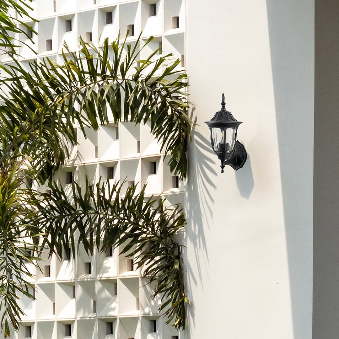 Black metal outdoor wall light lifestyle image on modern exterior wall for elegant outdoor lighting decor.