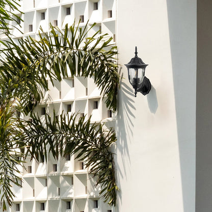 Black metal outdoor wall light lifestyle image on modern exterior wall for elegant outdoor lighting decor.