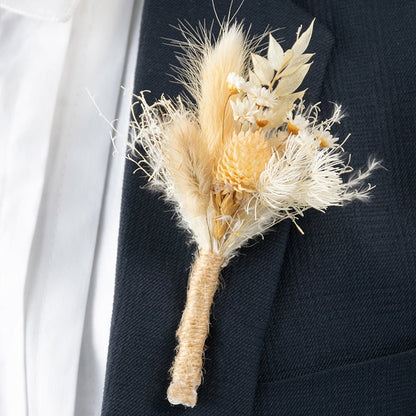 Closeup of dried flower boutonniere with natural beige stems and rustic jute wrap perfect for wedding and groom styling.