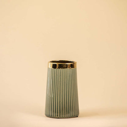 Stylish vertical-grooved vase in soft green with a polished gold rim showcased on a white backdrop emphasizing its modern design and smooth finish.