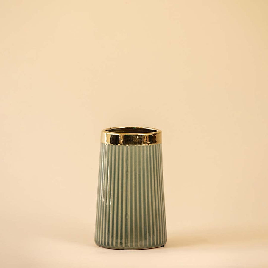 Stylish vertical-grooved vase in soft green with a polished gold rim showcased on a white backdrop emphasizing its modern design and smooth finish.