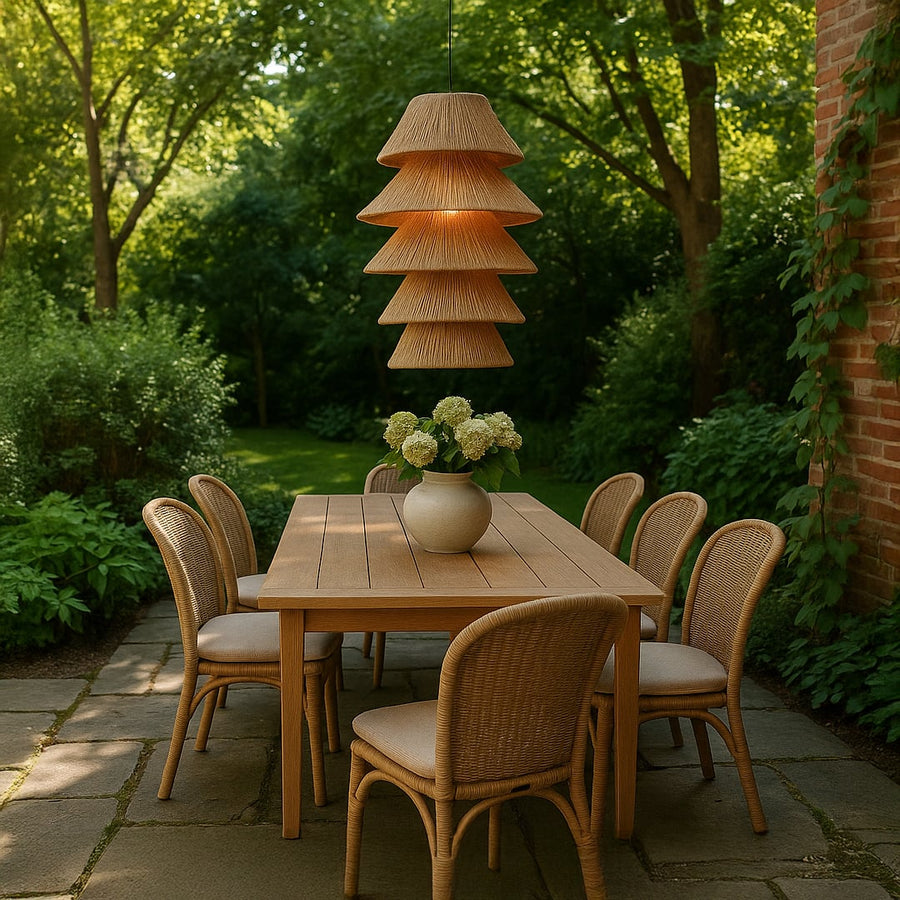 Natural jute pendant light above outdoor dining table adding warm coastal charm and artisan style to garden decor.