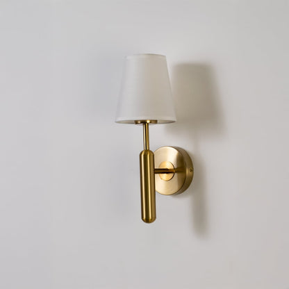 Gold metal wall light with white fabric shade displayed on a white background with light off highlighting its sleek minimal contemporary form.