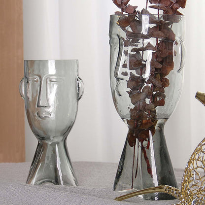 Set of abstract face design glass vases in clear finish artistic decorative modern style light on white background for display.
