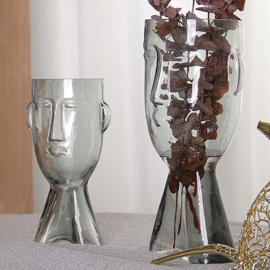 Set of abstract face design glass vases in clear finish artistic decorative modern style light on white background for display.