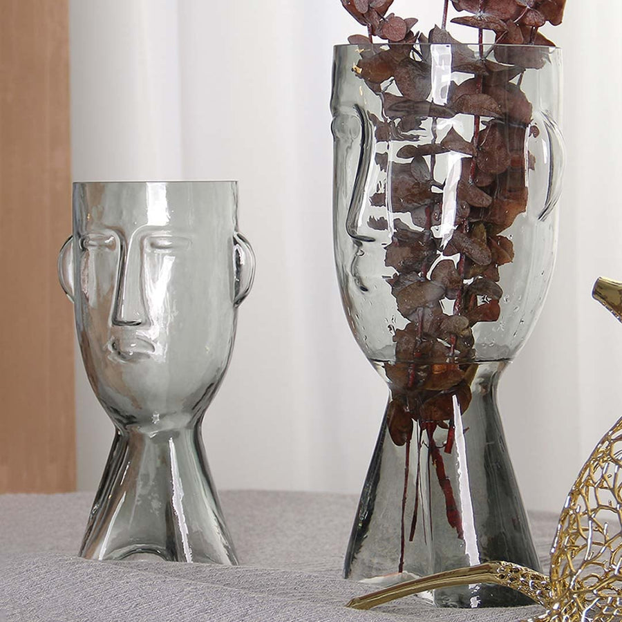 Set of abstract face design glass vases in clear finish artistic decorative modern style light on white background for display.