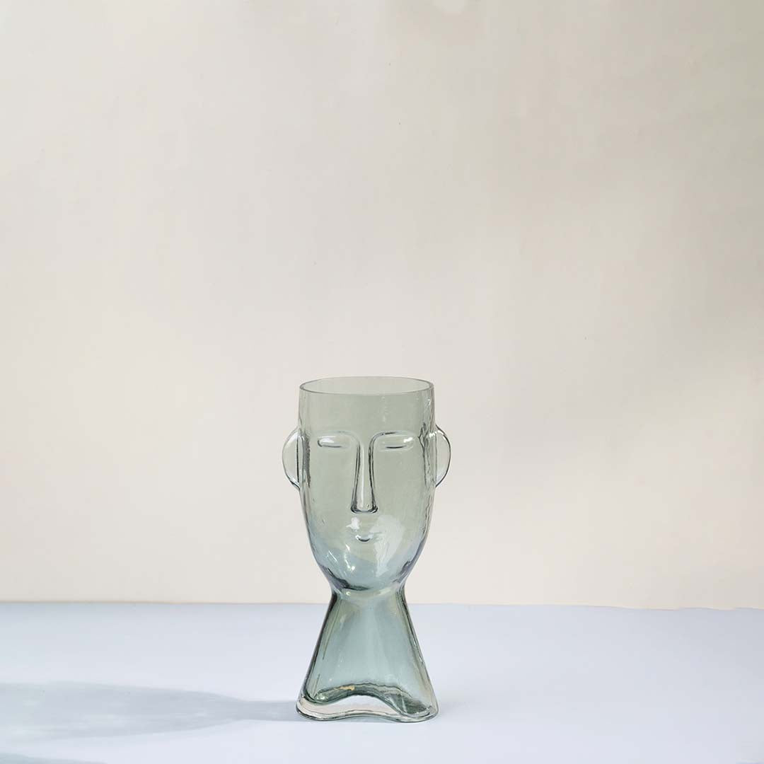 Light green glass decorative vase with sculptural face design for tabletop styling and modern home decor displays.