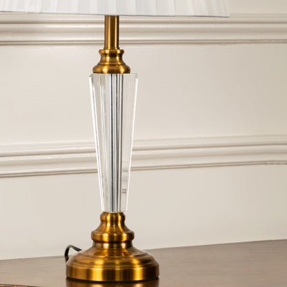 Closeup of crystal and gold lamp base with white pleated fabric shade highlighting elegant finish and details table lamp.