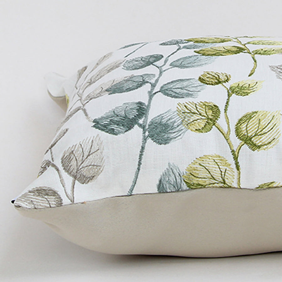 Soft cotton cushion cover with green and grey botanical design displayed at an angle providing a subtle nature inspired décor touch with a breathable gentle and skin friendly fabric finish.