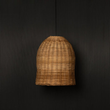 Dome-shaped rattan pendant light with natural handwoven bamboo shade turned off against black background.