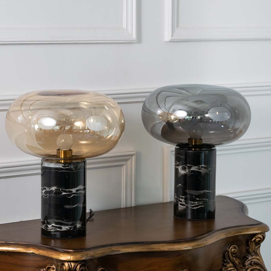 Collection of amber glass table lamps with black marble bases displayed on white background showcasing their sleek modern and artistic appeal.