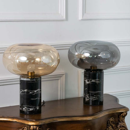 Collection of amber glass table lamps with black marble bases displayed on white background showcasing their sleek modern and artistic appeal.