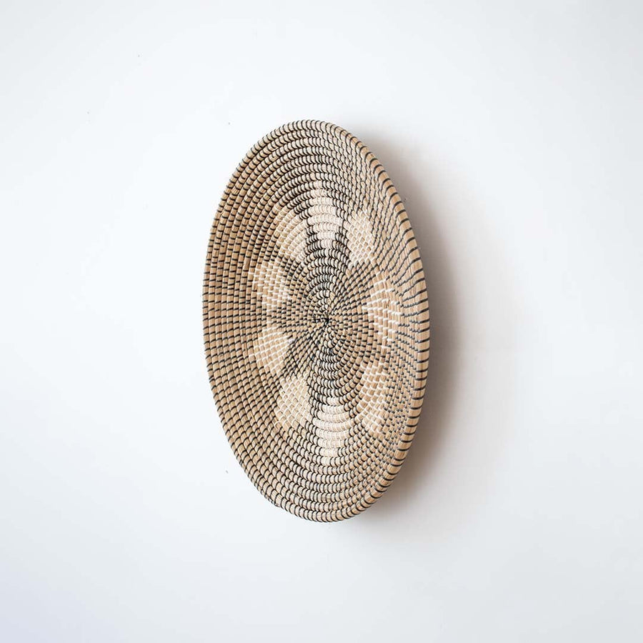 Side view of handwoven wicker basket wall decor showing woven texture and depth for modern boho home decoration.