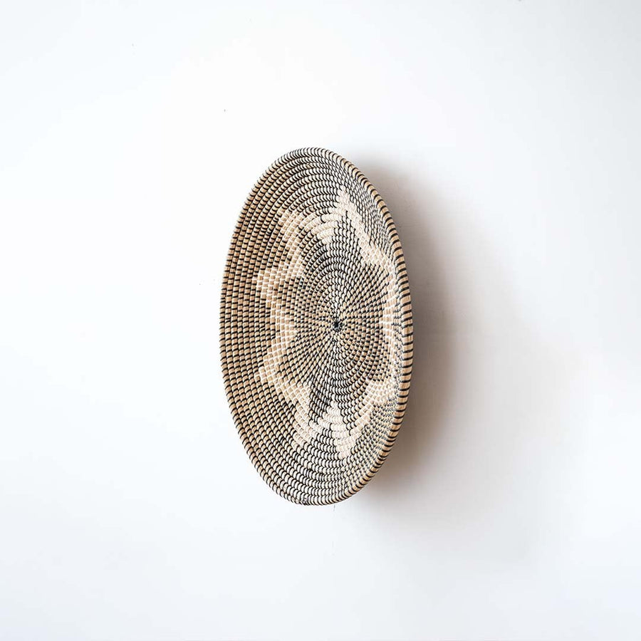 Side view of handwoven wicker basket wall decor showing woven depth and texture for modern boho and rustic interiors.