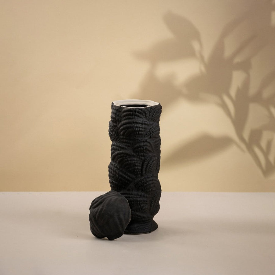 Modern handcrafted black ceramic vase with unique spiral pattern shown on white background perfect for minimalist interior decoration.