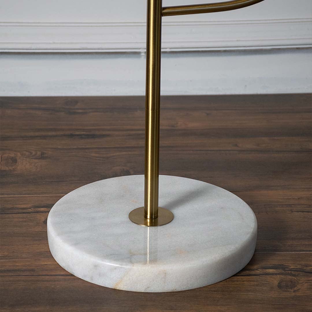 Closeup view of the lamp golden brass base and white globe shade focusing on craftsmanship and minimalist elegance.