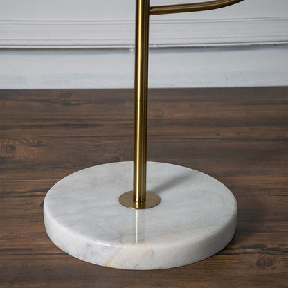 Closeup view of the lamp golden brass base and white globe shade focusing on craftsmanship and minimalist elegance.