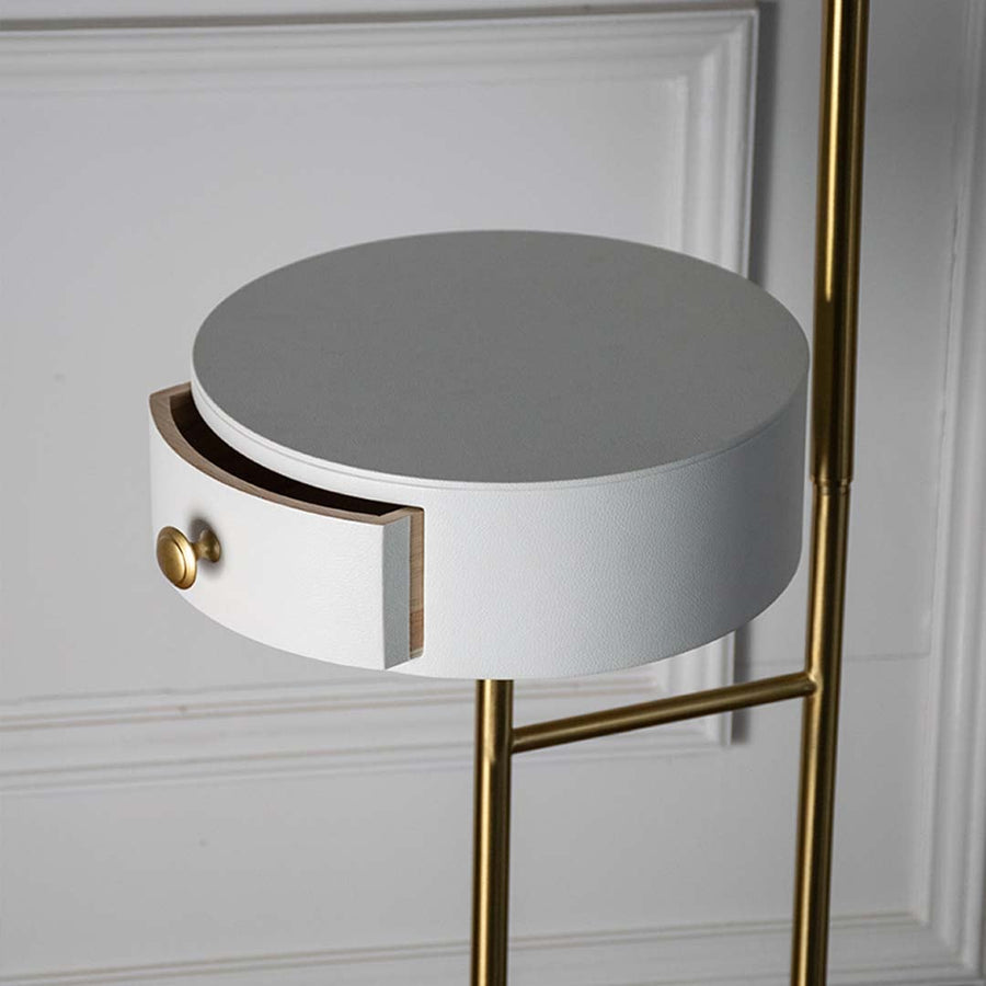 Closeup view of the lamp golden brass base and white globe shade focusing on craftsmanship and minimalist elegance.