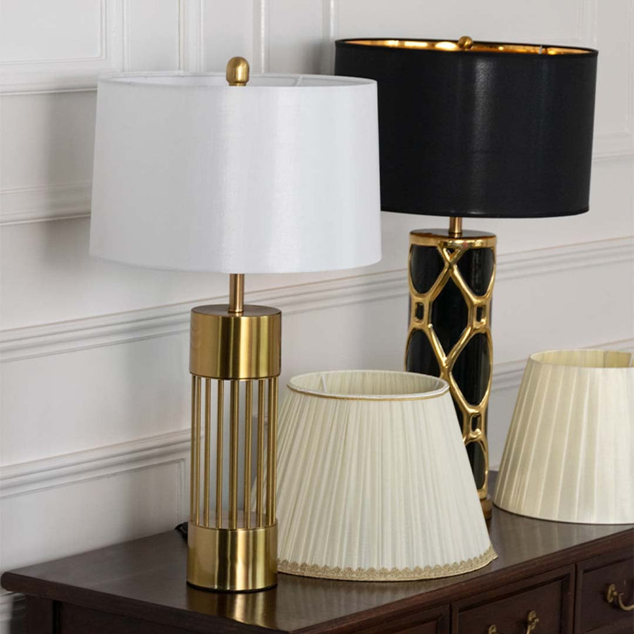 White shade gold metal table lamp on wooden console table with light off and white wall background for modern luxury home décor.